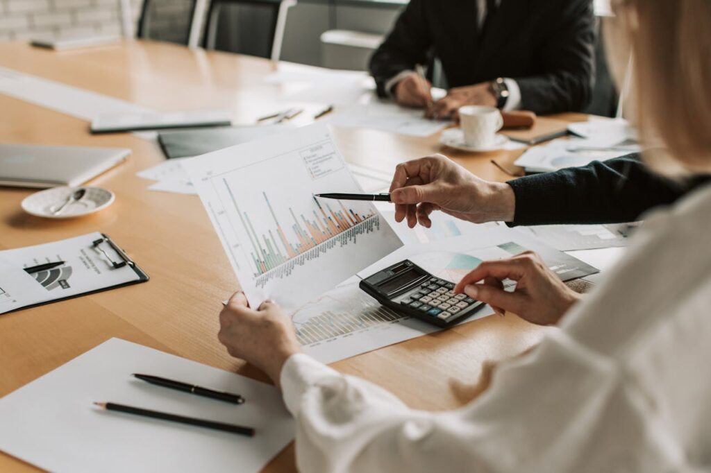 pexels-photo-7433837 Professionals reviewing financial graphs and charts during a meeting.